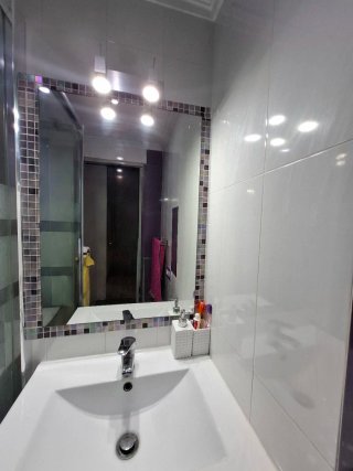 Mueble de baño blanco, espejo y armario pared.