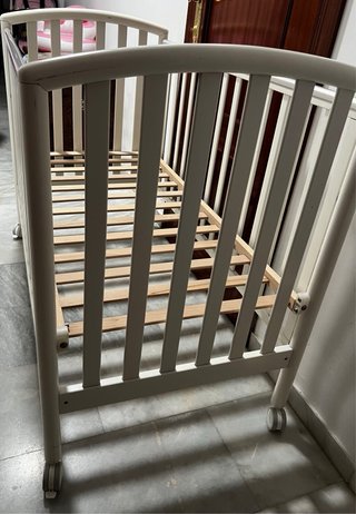 Cuna de bebé blanca con ruedas
