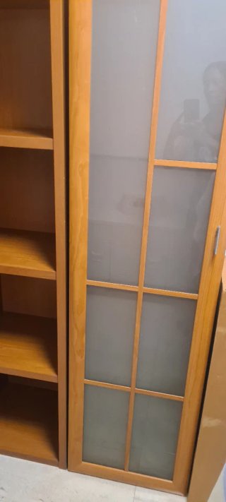Estantería de madera una  con puertas de cristal.