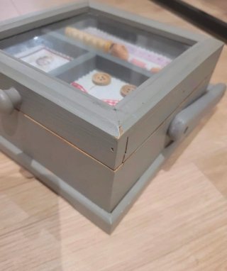 Costurero de madera gris con tapa de cristal