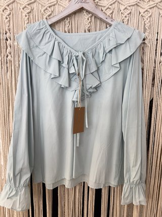 Blusa azul con volantes y lazada
