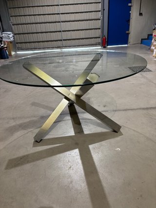 Mesa de diseño de cristal grueso y base de metal.