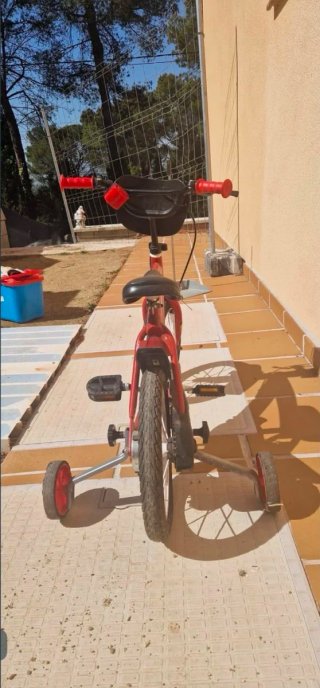 Bicicleta infantil roja con ruedines