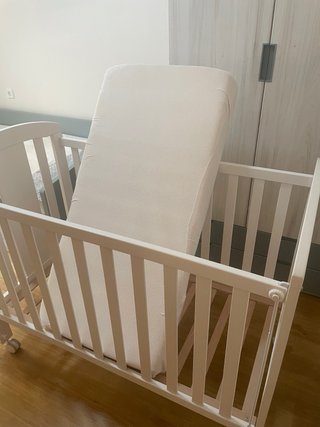 Cuna blanca con colchón y ropa de cama