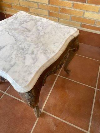 Mesa de mármol con patas de madera.