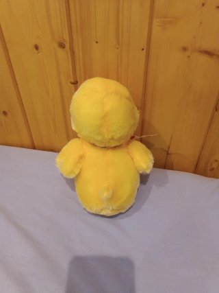 Pollito de peluche con lazo de colores