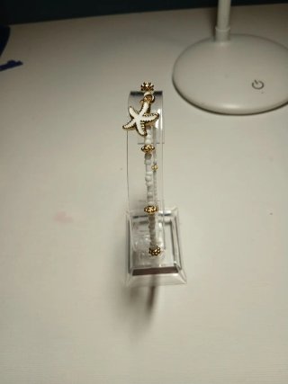 Pulsera blanca con abalorios dorados y estrella