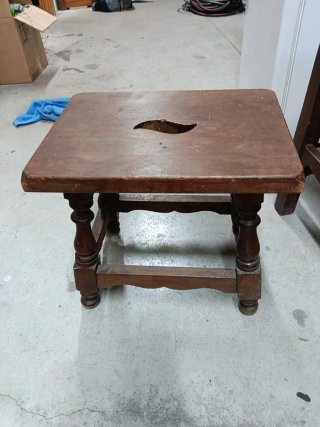 Taburete de madera antiguo con asiento tallado