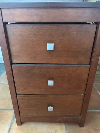 Mesita de noche de madera con cajones.