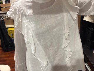 Blusa blanca con volantes y pompones