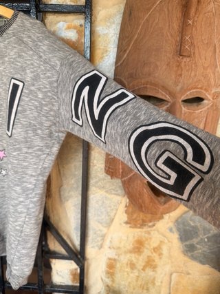 Sudadera gris con letras y estrellas