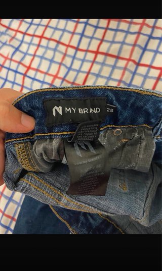 Jeans azules desgastados con logo naranja