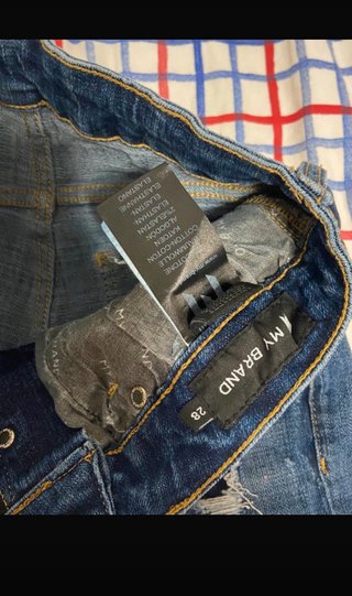 Jeans azules desgastados con logo naranja
