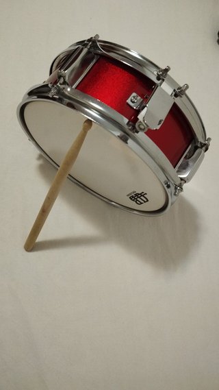 Tambor de percusión con baquetas