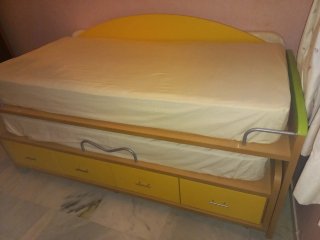 Dormitorio juvenil con cama nido y estanterías.