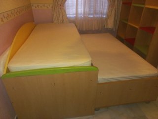 Dormitorio juvenil con cama nido y estanterías.