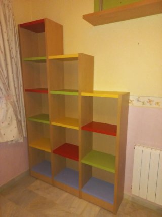 Dormitorio juvenil con cama nido y estanterías.