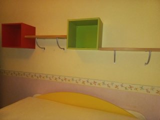 Dormitorio juvenil con cama nido y estanterías.