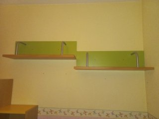 Dormitorio juvenil con cama nido y estanterías.