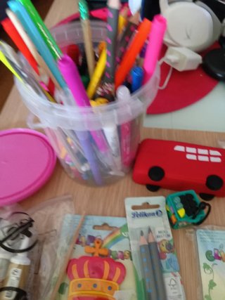 Material escolar variado: lápices, clips, pincel