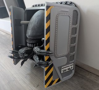 Figura de alien saliendo de la exclusa