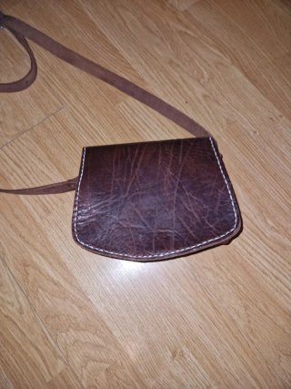 Bolso de cuero marrón con piedra morada.