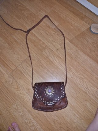 Bolso de cuero marrón con piedra morada.