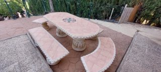 Mesa de piedra con loza y bancos