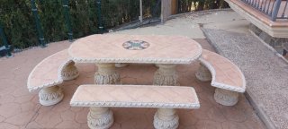 Mesa de piedra con loza y bancos