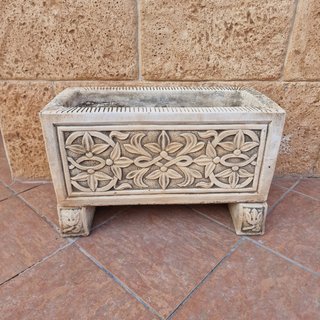 Macetero de piedra con relieve floral