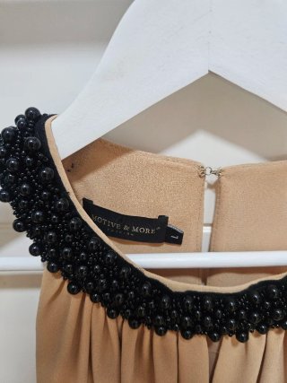 Camiseta beige con pedrería negra