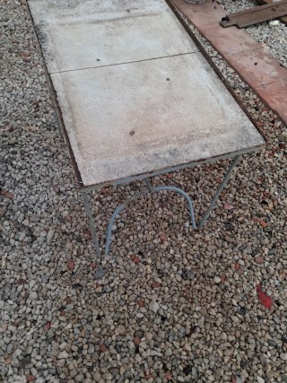 Mesa antigua de metal y piedra