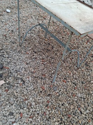 Mesa antigua de metal y piedra