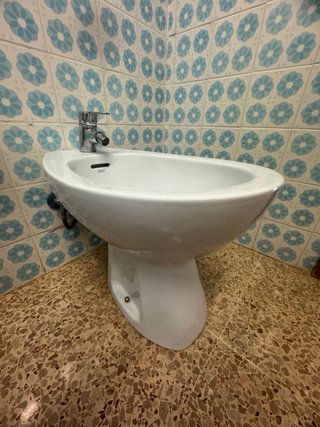 Bidé de cerámica blanco con grifo metálico