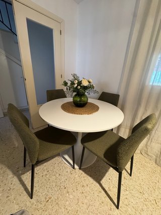 Mesa de comedor blanca redonda con 4 sillas verdes