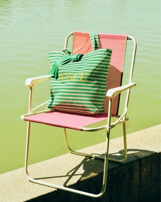 Revista Vogue agosto 2026 con bolso a rayas verde