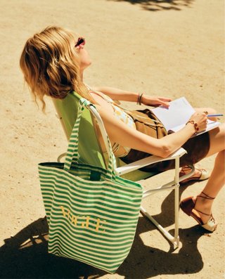 Revista Vogue agosto 2026 con bolso a rayas verde