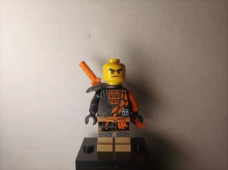 Muñeco Ninjago Cole naranja y negro con arma