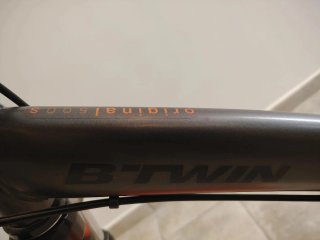 Bicicleta urbana naranja y negra.