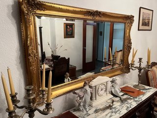 Espejo de salón dorado con marco tallado