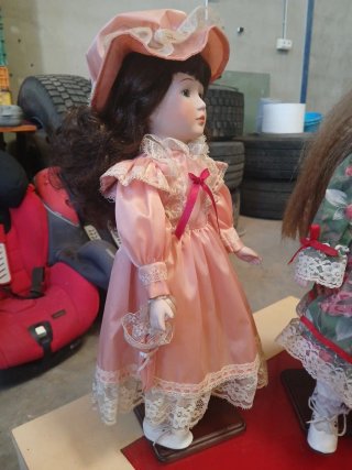Muñeca de porcelana con peana
