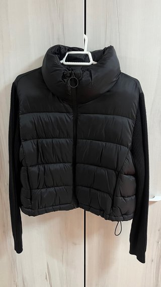 Chaqueta acolchada negra con mangas de punto