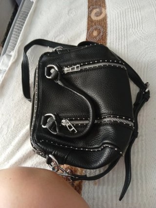 Bolso negro con cremalleras y tachuelas
