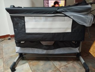 Mini cuna con mosquitera y ruedas.