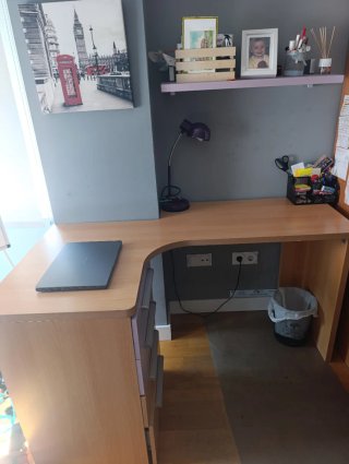 Escritorio de madera con cajonera y estantería.