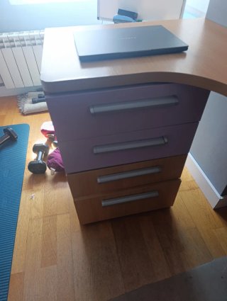 Escritorio de madera con cajonera y estantería.