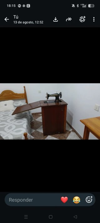 Máquina de coser antigua con mueble de madera