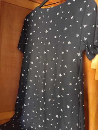 Vestido negro o azul oscuro con estampado floral.