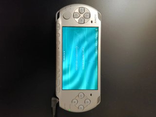 PSP Slim Argento + Fotocamera Sony + Caricatore Senza Batteria