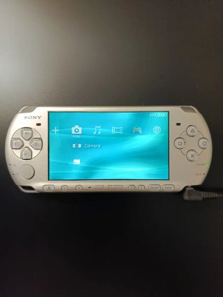 PSP Slim Argento + Fotocamera Sony + Caricatore Senza Batteria